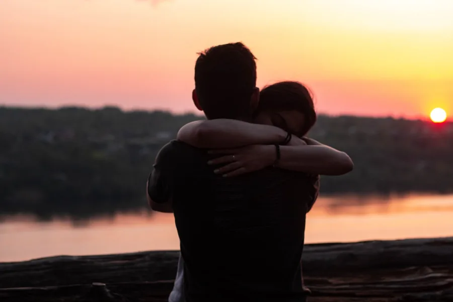 Pareja abrazándose al atardecer
